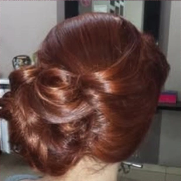 Copper hair arranged in a polished formal updo by Jose Manuel