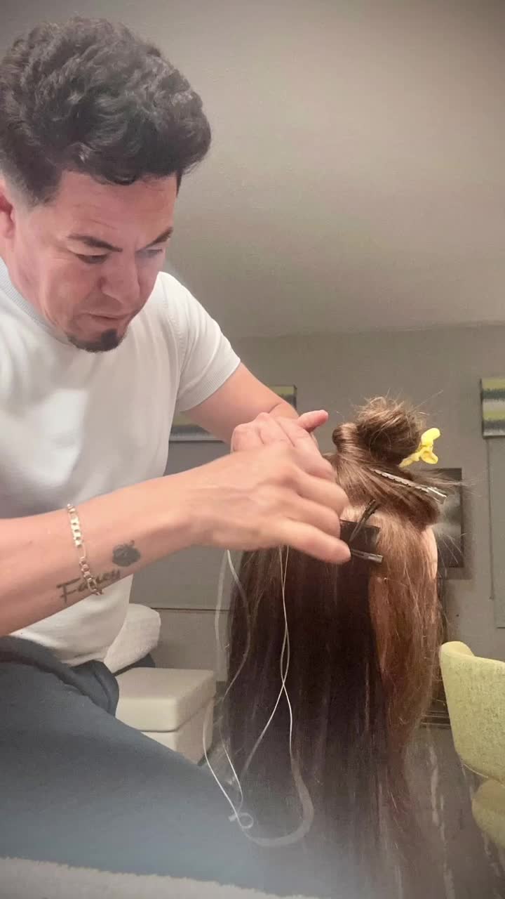 Jose Manuel installing hair extensions for a client